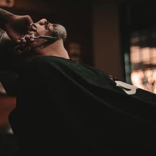 A barber finishing a hot-towel shave