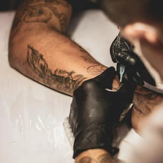 A tattoo being worked on the forearm